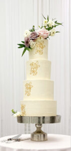 Four tiered wedding cake with 24 karat edible gold leaf and fresh floral.