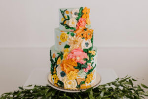 Three tiered cake with buttercream and hand painted abstract floral